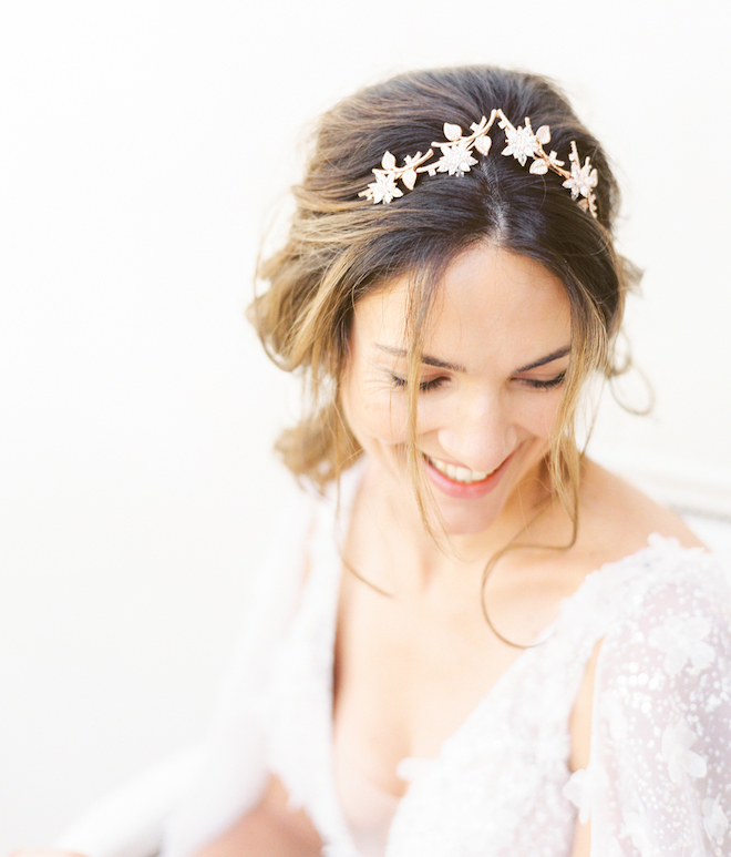 The bride smiling with a floral headpiece in her hair.