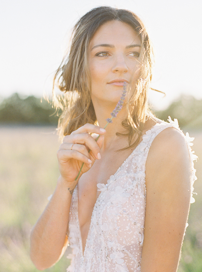 The bride holding up a wildflower in the lavender fields during the elopement editorial in the South of France.