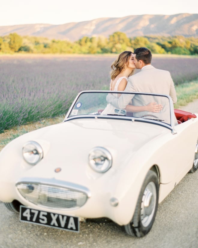 The bride and groom kissing in a vintage car in Provence, France.