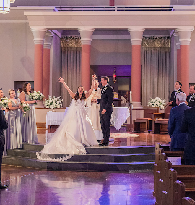 The bride cheering at the altar during her wedding ceremony. 