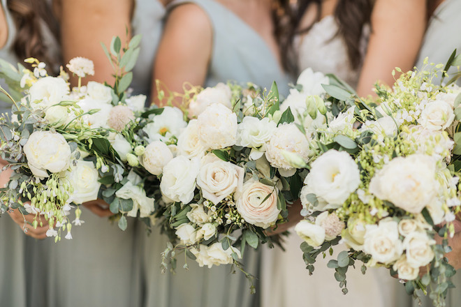 The bride and bridesmaids white, sage and blush wedding bouquets.