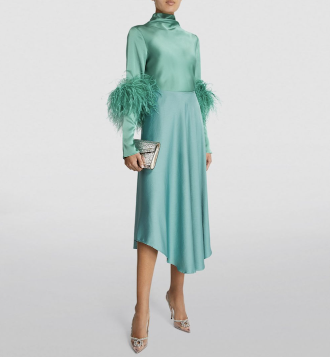 A sea foam green satin midi skirt with a feathered trim top.