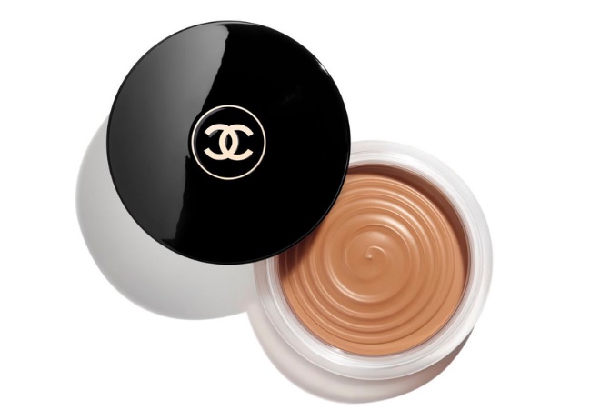 A brown bronzer in a container with a black lid that has the Chanel "CC" logo in the middle.
