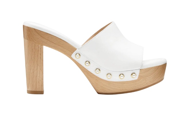 A wooden heel with a white strap and gold studs on the side. 