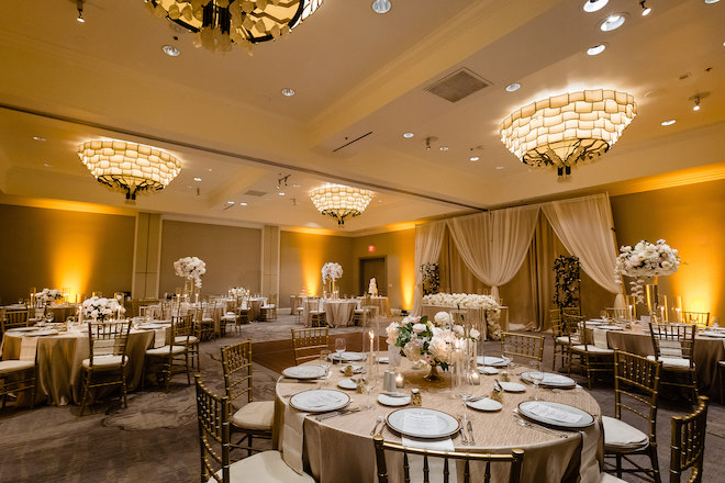 The ballroom with round tables and floral centerpieces.