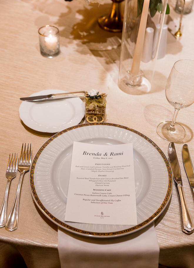 A white and gold table setting with "Brenda & Rami" written on the menu. 