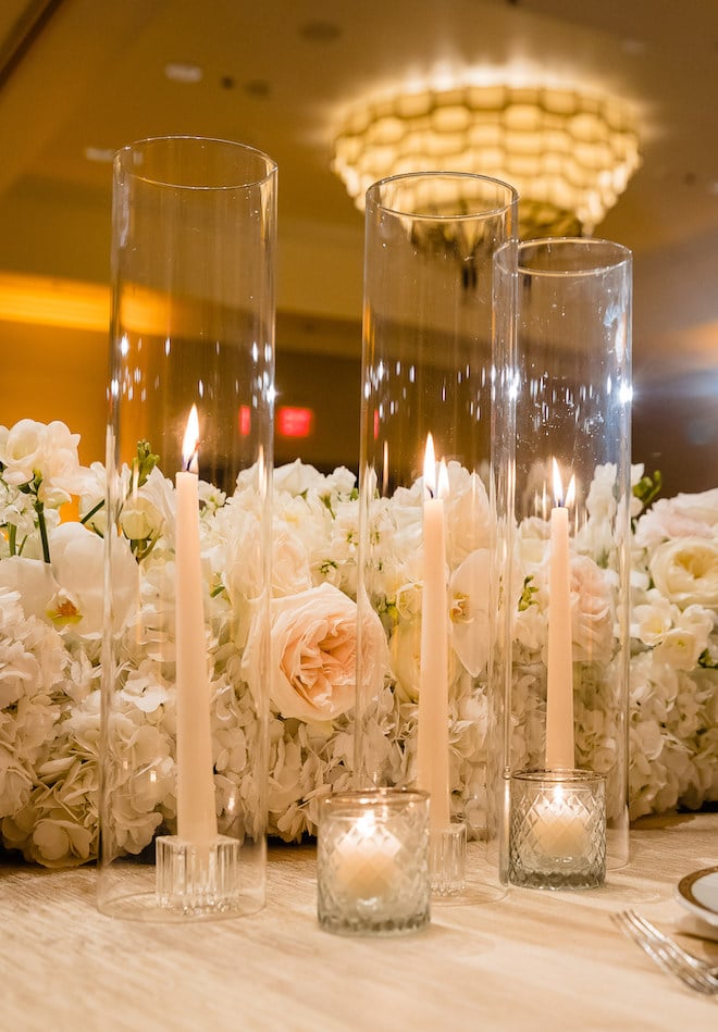 White and light pink flowers and light pink pillar candles.