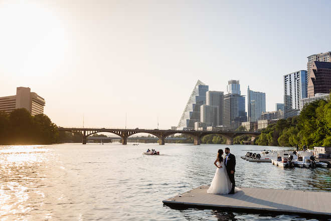 The bride and groom looking at each other on a boardwalk with downtown Austin in the background.