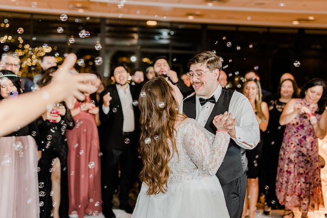 The bride and groom dancing with bubbles around them. 