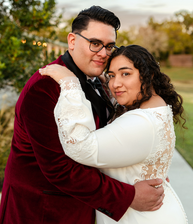 The bride and groom hugging and smiling during sunset. 