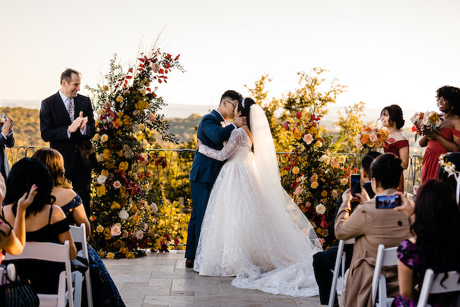The bride and groom kissing at the altar of their alfresco autumn ceremony. 