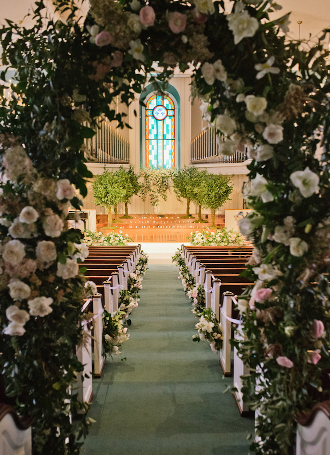 An arch of greenery and florals as the entrance to the church.