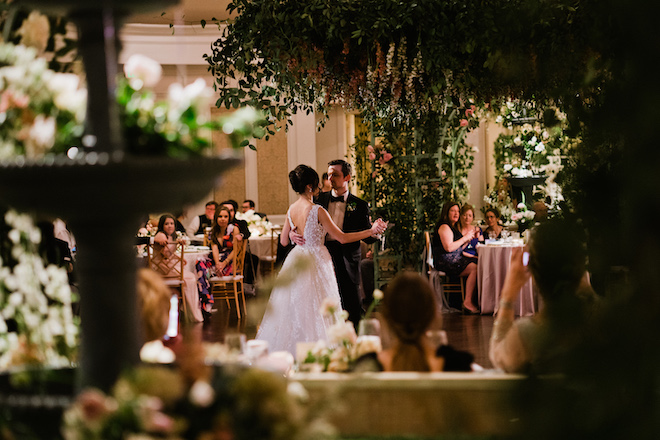 The bride and groom dancing under the french inspired florals. 