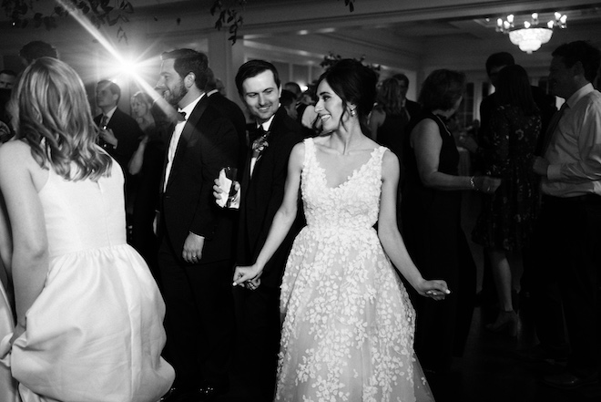 The bride and groom dancing at the reception with their guests. 
