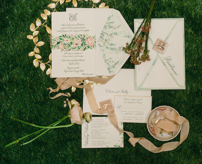 An garden-inspired wedding invitation suite with pink and green florals printed on the stationery. 