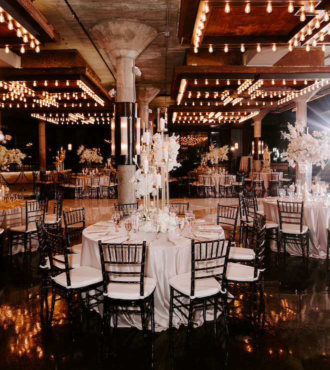 Round tables decorated with tall floral arrangements and candles at the industrial chic venue, The Astorian. 