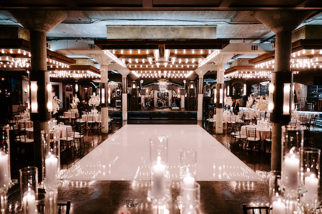 The industrial chic venue, The Astorian, decorated with a white dance floor and candles. 
