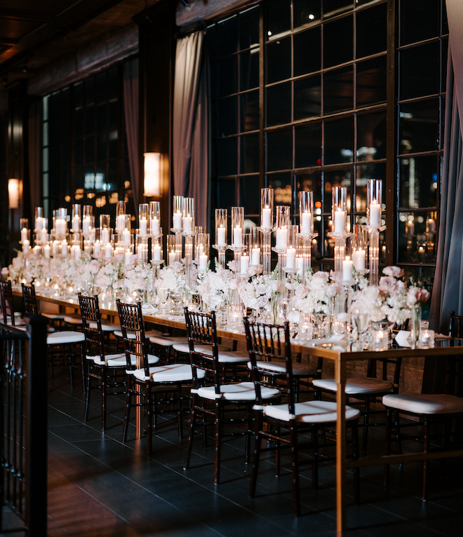 A family style mirrored table with candles and florals. 