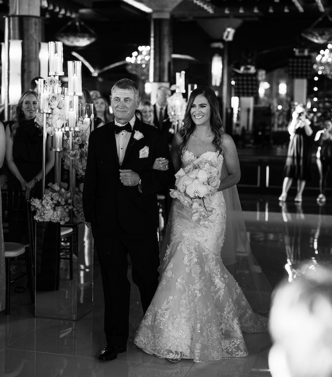 The bride and groom walking down the aisle at the industrial chic venue, The Astorian. 