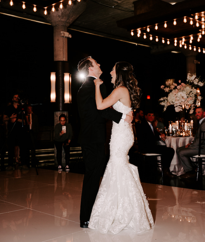The bride and groom laughing on the dance floor during their first dance. 