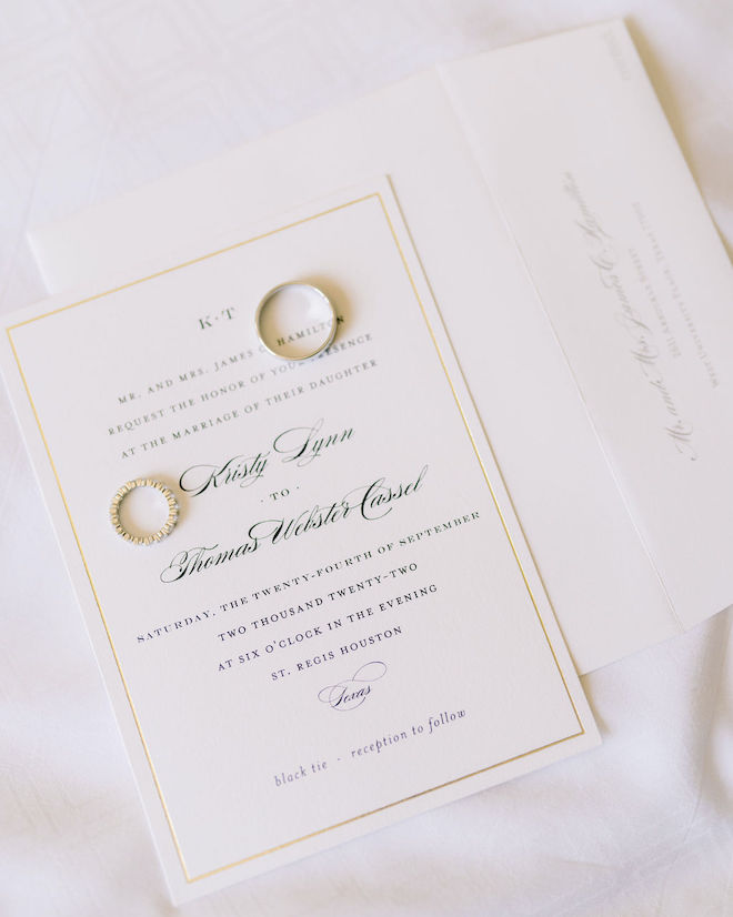 The bride and groom's wedding bands on a wedding invitation for a wedding on September 24, 2022 in Houston, Texas. 