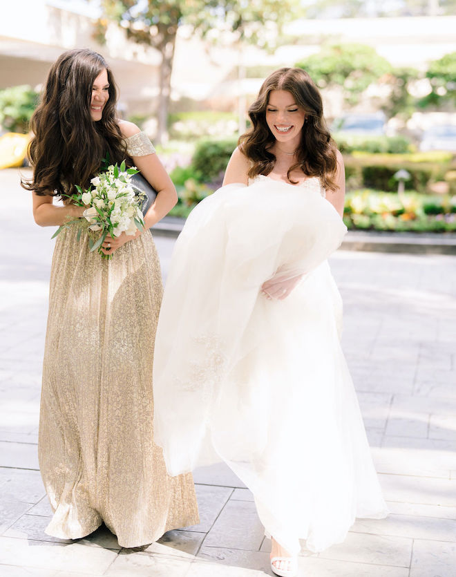 The bride and one of her bridesmaids share a laugh outside of the Houston hotel wedding venue. 