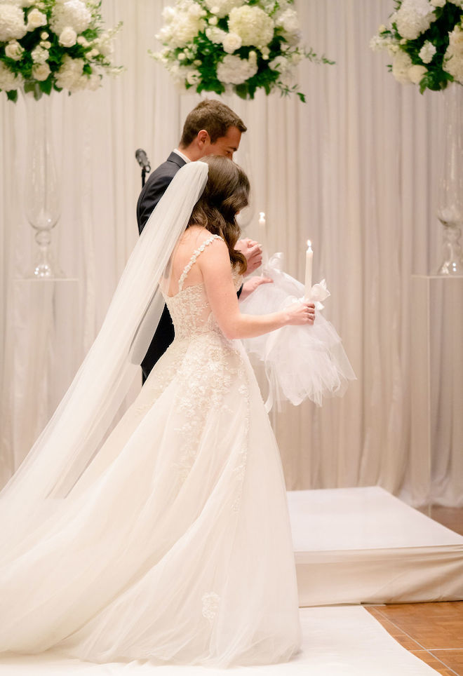 The bride and groom participate in a fusion of Methodist and Eastern Orthodox rituals during their wedding ceremony. 