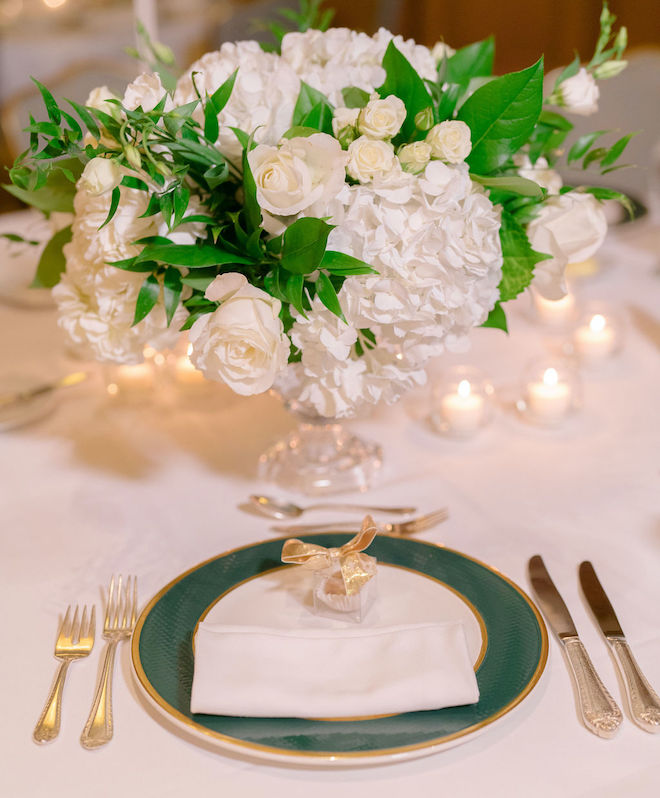 White hydrangeas are the centerpieces for the reception tables to match the green and gold wedding decor. 