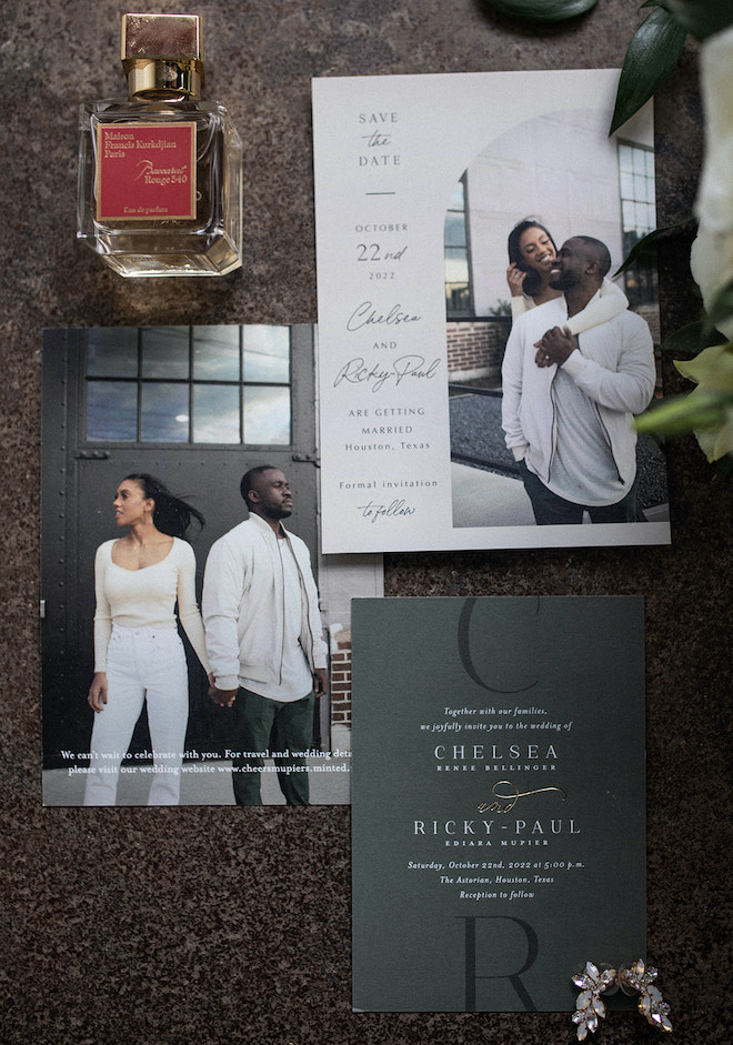 A emerald and white invitation suite with the couple's engagement photos on them, a perfume bottle and the bride's earrings.