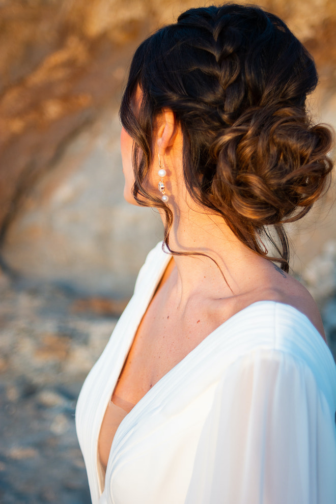 The bride's updo hairstyle with a braid going into a loose bun.
