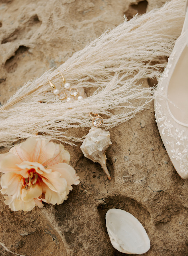 Pampas grass, shells, the brides jewelry and the bride's white heel. 
