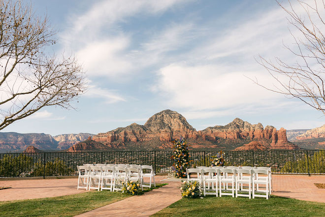 White chairs facing the ceremony space overlooking the Sedona mountains. 