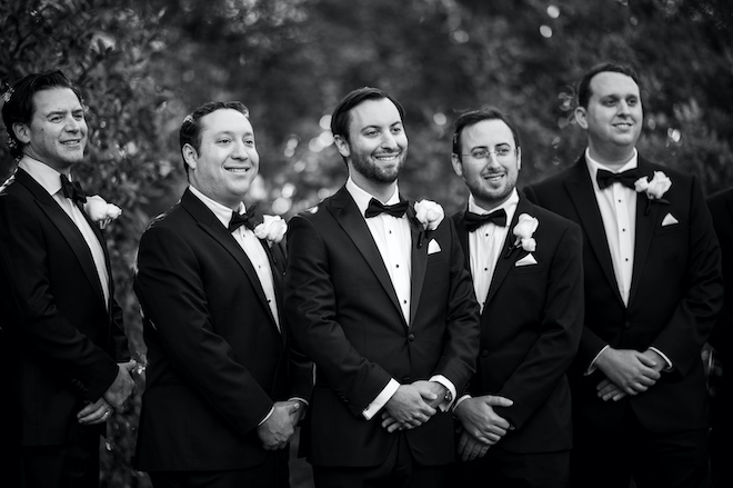 The groom smiling with his groomsmen. 