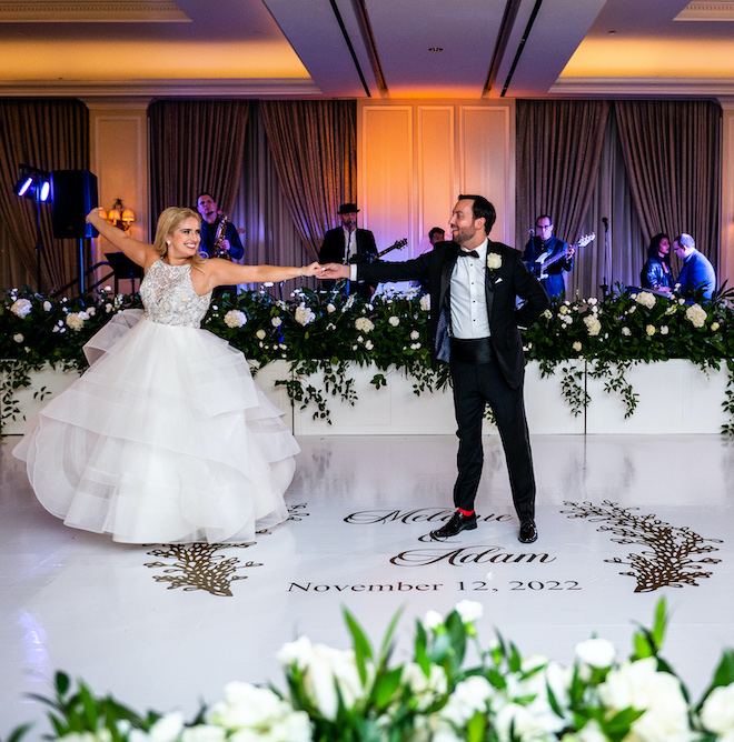 The bride and groom dancing on their custom dance floor with the band playing behind them.