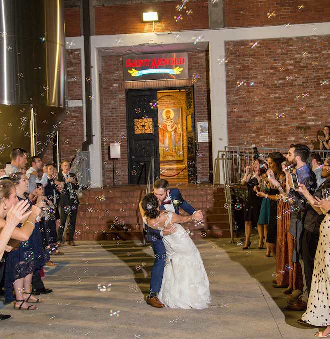 Bride and groom kiss outside of Houston historic brewery and wedding venue, Saint Arnold Brewery.