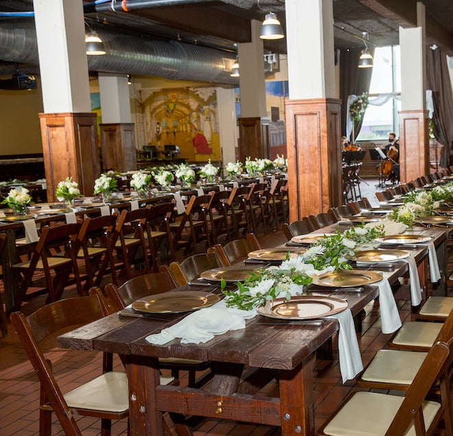 Interior of Saint Arnold Brewery set-up for a wedding reception with family-style tables 