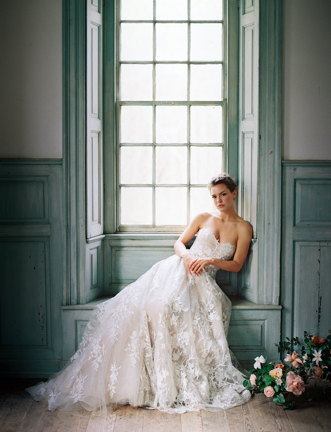 A bride sitting on a blue windowsill at the historic Salubria manor.