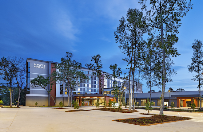 A rendering of the exterior of Hyatt Regency Conroe at twilight. 