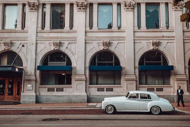 The exterior of Hotel Icon with a blue vintage car parked in front.