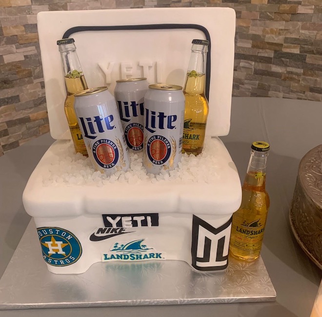 A yeti cooler cake with stickers and beer. 