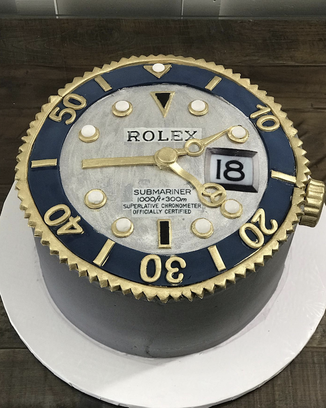 A Rolex-styled watch with blue and gold accents is designed by For Heaven's Cake for the groom. 