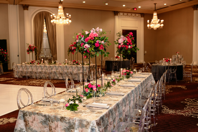 Family style long table with pink and gray linens and tall floral centerpieces in the glam hotel ballroom. 