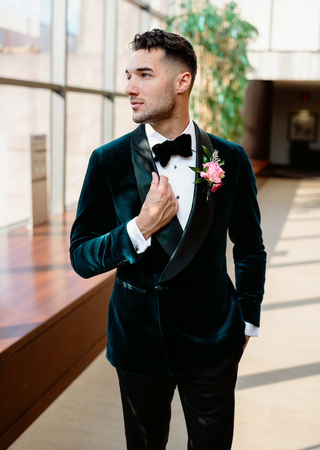 The groom looking to the side wearing a velvet emerald green suit from b.Kreps&Co.