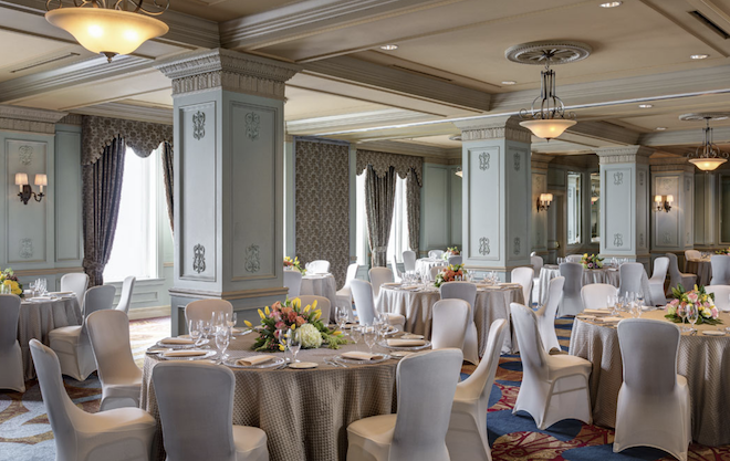 A ballroom with green walls and large windows.