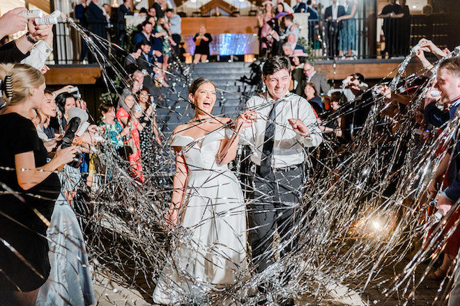 Bride and groom smiling during a streamer send-off on their spring wedding day in Houston, Texas.
