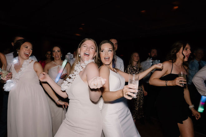 The bride and bridesmaid dancing together and singing. 