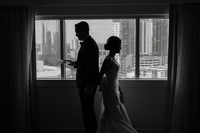 The bride and groom back-to-back reading lettings to each other. 