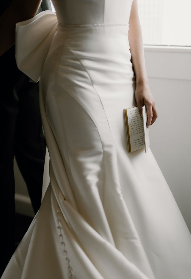 The bride holding the book of her written vows.