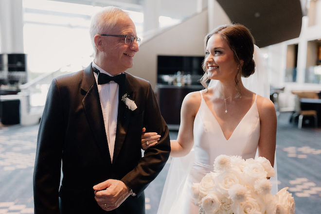 The bride and her father smiling at each other before the wedding ceremony. 