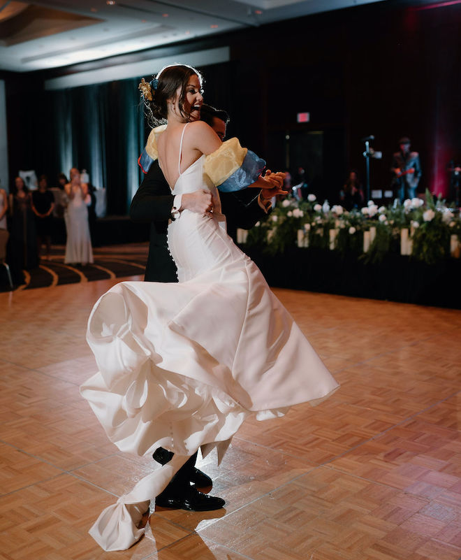 The bride and groom performing a salsa dance on the dance floor. 